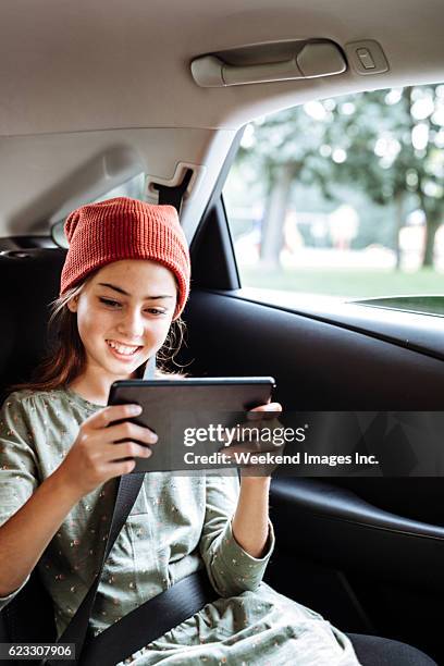 pre-teen student in einem auto - girl in car with ipad stock-fotos und bilder