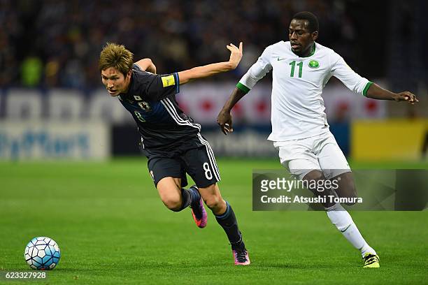 Genki Haraguchi of Japan and Abdulmalek Al Khaibri of Saudi Arabia compete for the ball during the 2018 FIFA World Cup Qualifier match between Japan...
