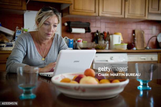 French far right party, the National Front's vice-president Marine Le Pen works on her computer on July 28, 2010 in La Trinite-sur-Mer, northern...