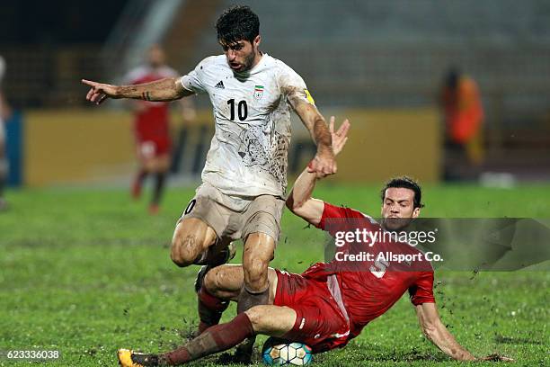 Karim Ansari of Iran is checked by Omro Al Midani of Syria during the 2018 FIFA World Cup Qualifier match between Iran and Syria at Tuanku Abdul...