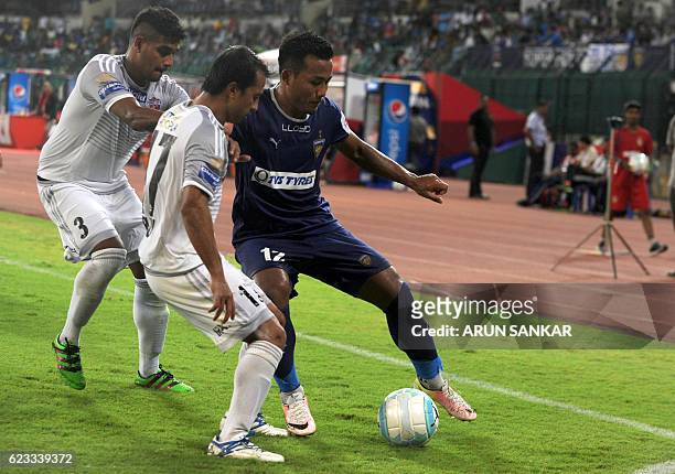 Chennaiyin FC' forward Jeje Lalpekhlua vies for the ball with FC Pune City's defenders Augustin Fernandes and Yamnam Raju during the Indian Super...