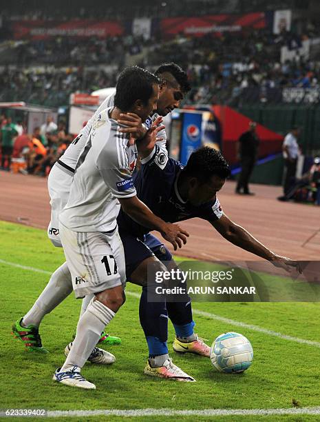 Chennaiyin FC forward Jeje Lalpekhlua vies for the ball with FC Pune City's defender Augustin Fernandes and Yamnam Raju during the Indian Super...