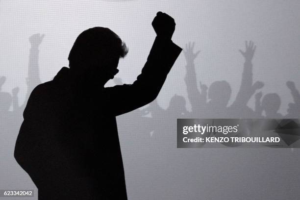 French Front de Gauche leftist party candidate for the 2012 French presidential election, Jean-Luc Melenchon raises his fist as he passes in...