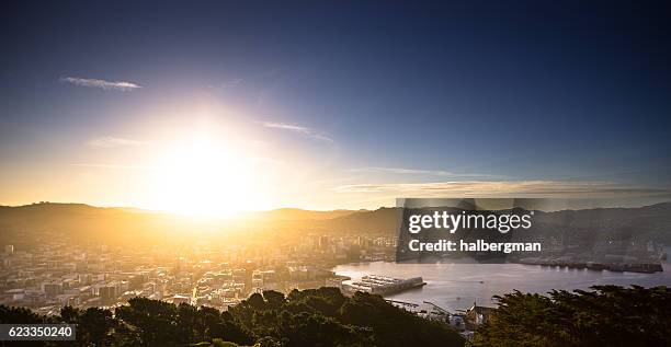 sun hitting the horizon over wellington harbour - wellington new zealand harbour stock pictures, royalty-free photos & images