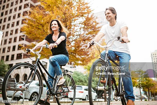 mature couple on bikes in austin texas - 45 couple stockfoto's en -beelden