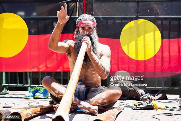 aboriginal male playing didgeridoo, street performer, sydney australia - ceremonie stockfoto's en -beelden