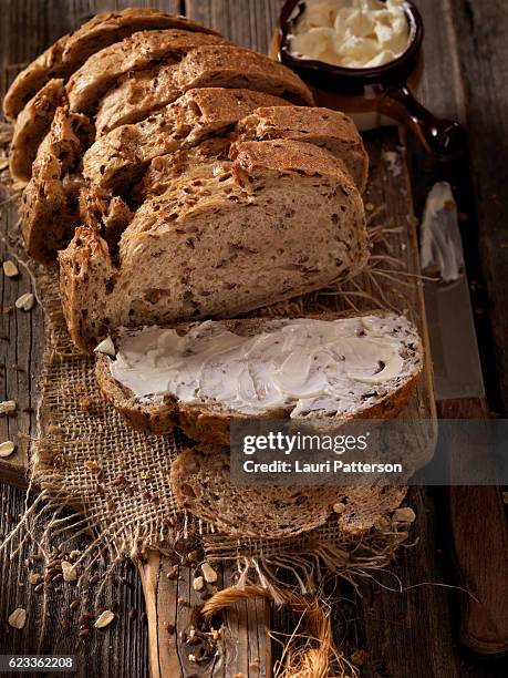 9 grain artisan bread loaf with butter - buttering stock pictures, royalty-free photos & images