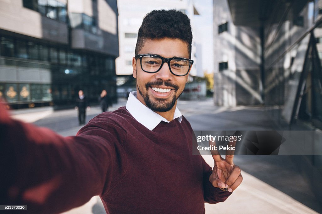 Young black business man taking funny selfie