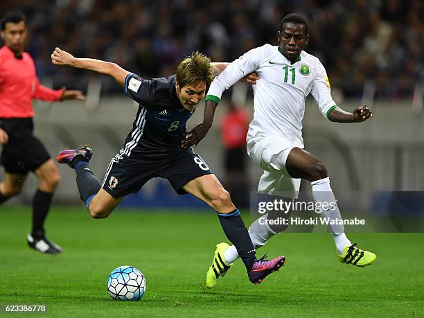 Genki Haraguchi of Japan and Abdulmalek al Khaibri of Saudi Arabia compete for the ball during the 2018 FIFA World Cup Qualifier match between Japan...