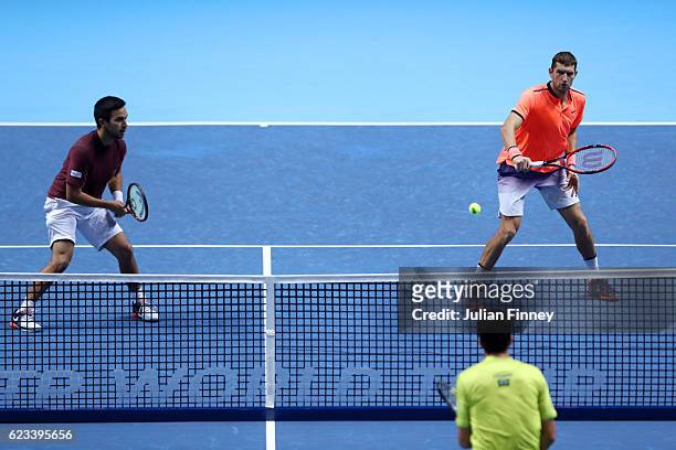 Max Mirnyi of Belarus hits a volley next to his partner Treat Huey of the Philippines during their men's doubles match against Ivan Dodig of Croatia...