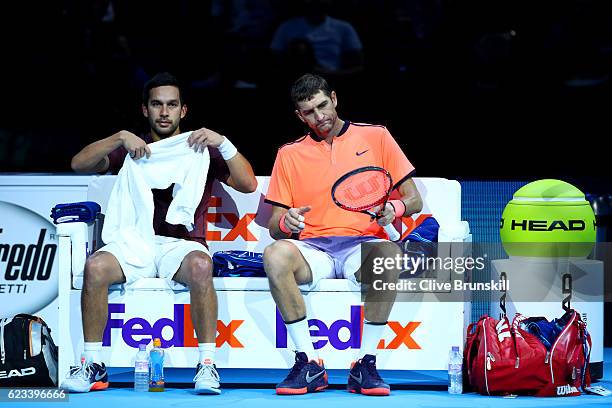 Max Mirnyi of Belarus looks on next to his partner Treat Huey of the Philippines during a break in their men's doubles match against Ivan Dodig of...