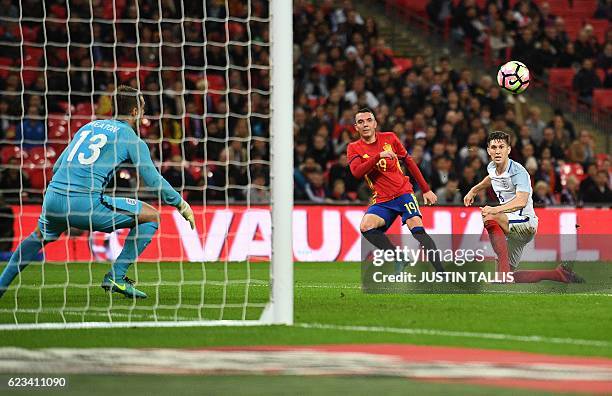 Spain's forward Iago Aspas shoots past England's defender John Stones and England's goalkeeper Tom Heaton to score his team's first goal during the...