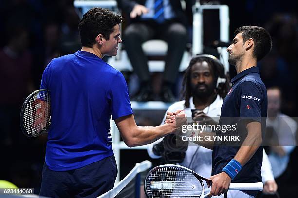 Serbia's Novak Djokovic shakes hands with Canada's Milos Raonic after winning their round robin stage men's singles match on day three of the ATP...