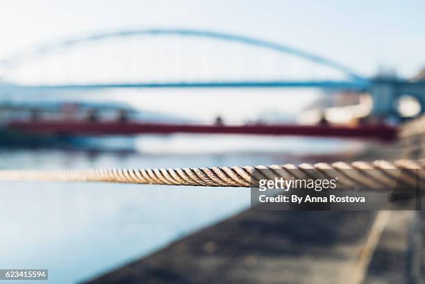 wire rope holding boat mooring with bridge in the background - moored stock pictures, royalty-free photos & images
