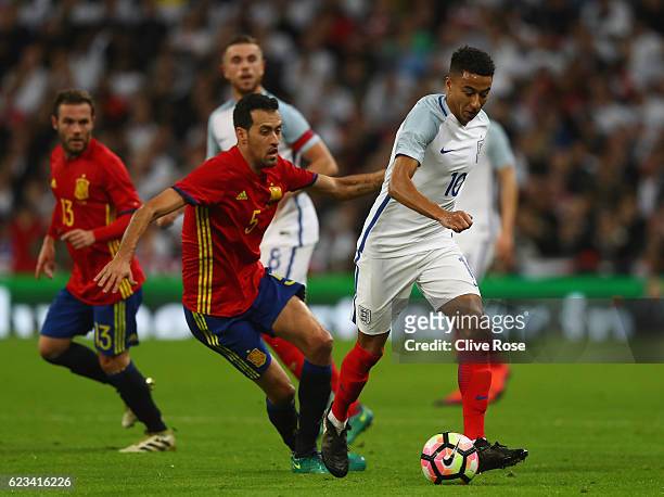 Jesse Lingard of England evades Sergio Busquets of Spain during the international friendly match between England and Spain at Wembley Stadium on...
