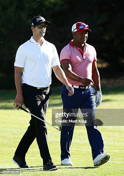 Adam Scott of Australia walks up the 5th fairway with Brian Lara during the pro-am ahead of the Australian Golf Open at Royal Sydney Golf Club on...