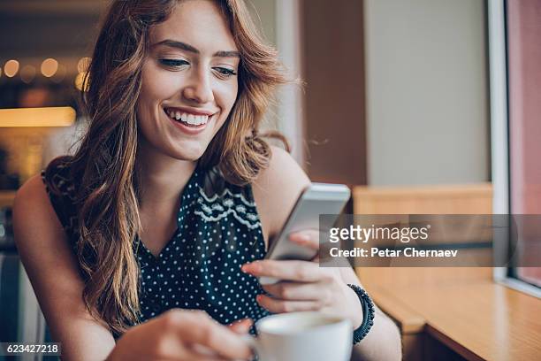 beautiful girl texting in cafe - happy customer stock pictures, royalty-free photos & images