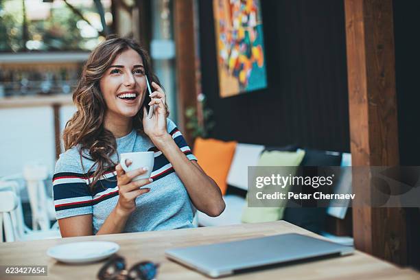 young woman with phone and coffee - girls chatting cafe stock pictures, royalty-free photos & images