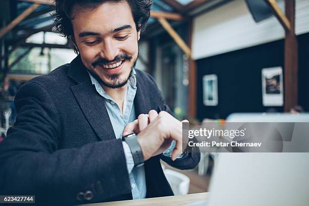 man checking his smart watch - wristwatch imagens e fotografias de stock