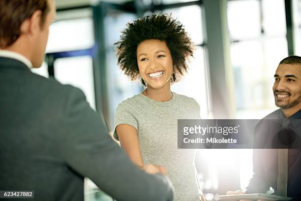 she's eager and excited to be joining a new team - black business woman shaking hands stock pictures, royalty-free photos & images
