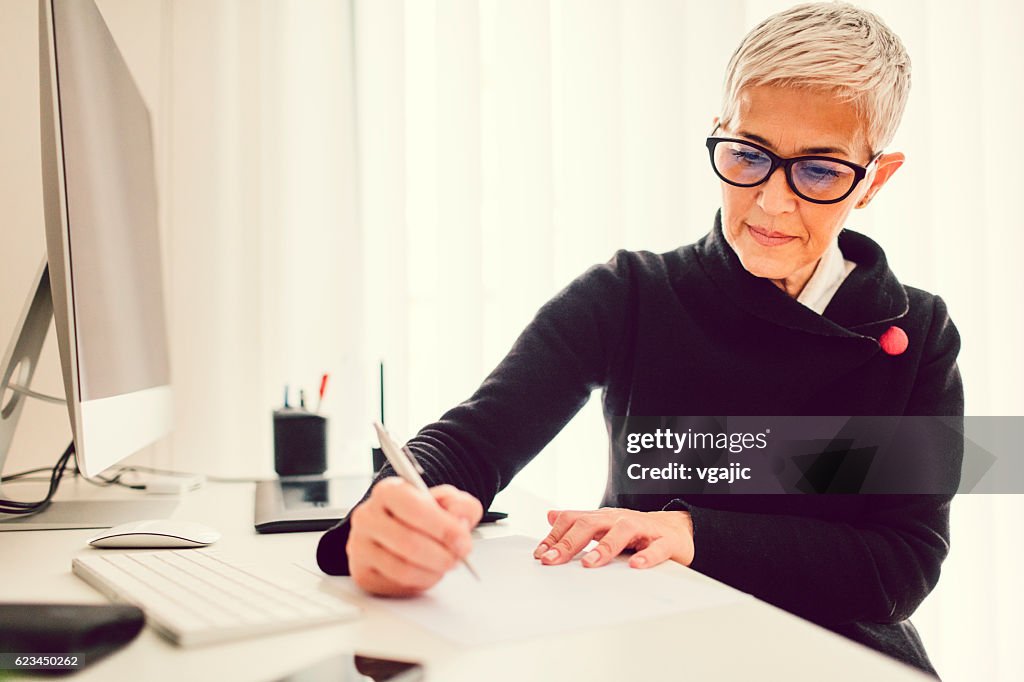 Mature Businesswoman Working In Her Home Office.