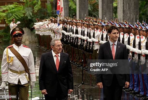 Canada's Prime Minister Justin Trudeau and Cuban President Raul Castro review the guard of honour during a ceremony at Revolution Palace on November...