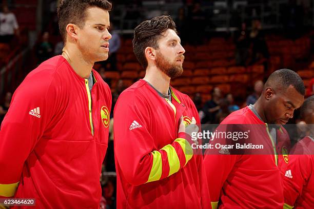 Kris Humphries, Ryan Kelly and Paul Millsap of the Atlanta Hawks stand for a moment of silence for the National Anthem before the game against the...