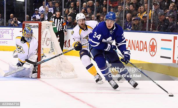 Auston Matthews of the Toronto Maple Leafs carries the puck past Yannick Weber and Marek Mazanec of the Nashville Predators during the first period...
