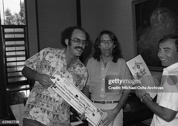 Manager Shep Gordon and musician Alice Cooper hold a check made out to the Hollywood Chamber of Commerce to buy the "O" in the Hollywood sign in...