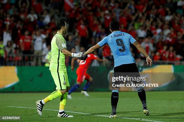 Chile's goalkeeper Claudio Bravo and Uruguay's Luis Suarez shake hands after Bravo stopped Suarez' penalty kick during their 2018 FIFA World Cup...