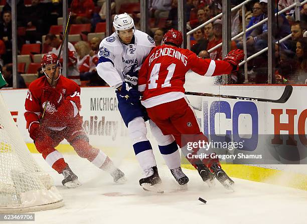 Braydon Coburn of the Tampa Bay Lightning takes a first period hit from Luke Glendening of the Detroit Red Wings at Joe Louis Arena on November 15,...