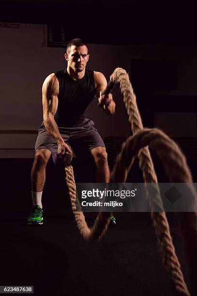 joven en el gimnasio entrenando con cuerdas - crossfit training fotografías e imágenes de stock
