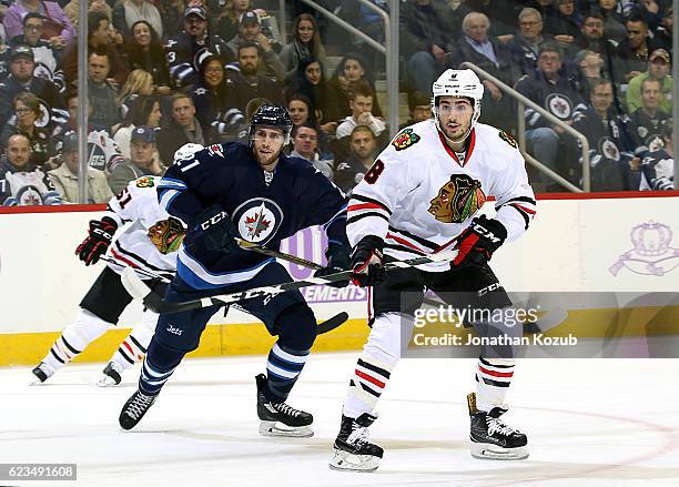 Quinton Howden of the Winnipeg Jets and Nick Schmaltz of the Chicago Blackhawks keep an eye on the play during first period action at the MTS Centre...