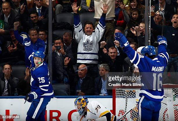 James van Riemsdyk of the Toronto Maple Leafs celebrates his goal on Nashville Predators goalie Marek Mazanec with teammate Mitchell Marner during...