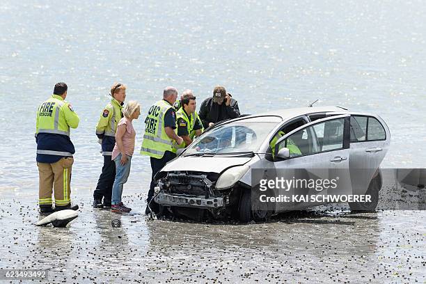 Emergency services try to get an injured man out of his car at the scene where a man crashed his car into the sea on November 16, 2016 in...
