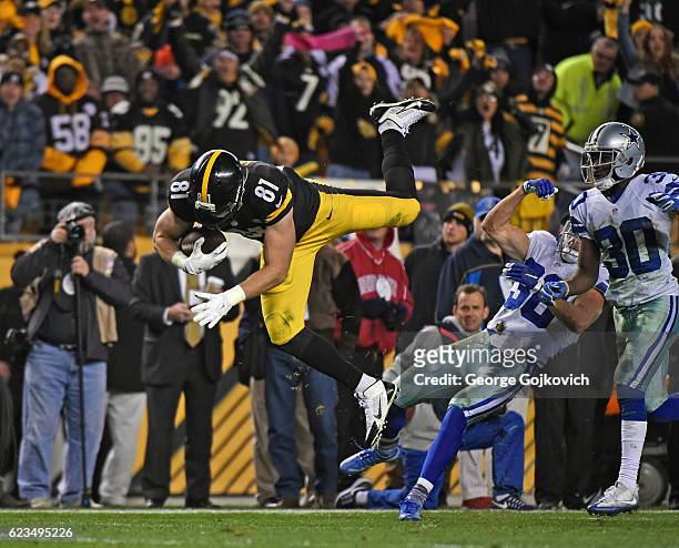 Tight end Jesse James of the Pittsburgh Steelers falls forward after leaping over safety Jeff Heath of the Dallas Cowboys as cornerback Anthony Brown...