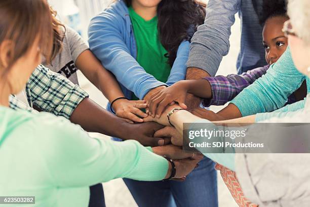 diverse group of volunteers put hands together - membership community business stockfoto's en -beelden