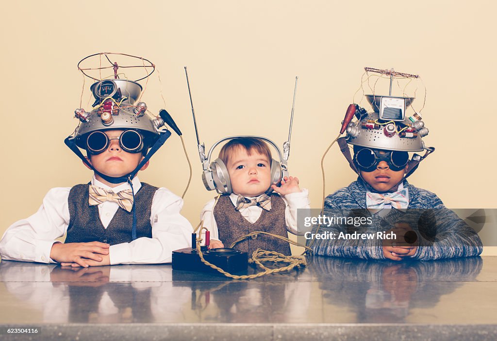Três meninos vestidos de nerds com capacetes de leitura da mente