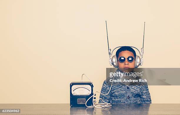 エイリアンヘッドフォンでオタクに身を包んだ若い男の子 - テレパシー ストックフォトと画像