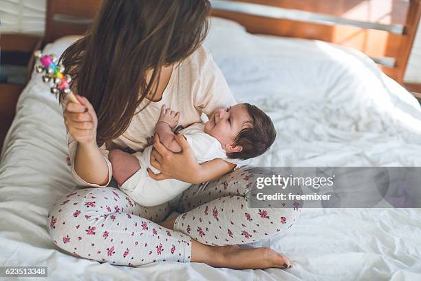 mother and daughter time - baby rattle stock pictures, royalty-free photos & images