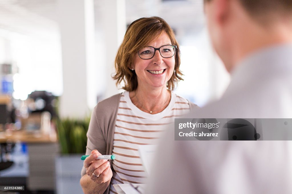 Une femme patronne parle avec son collègue