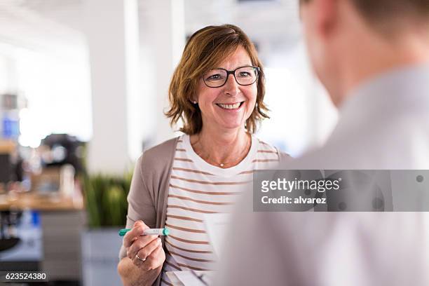 woman boss speaking with her colleague - talking stock pictures, royalty-free photos & images