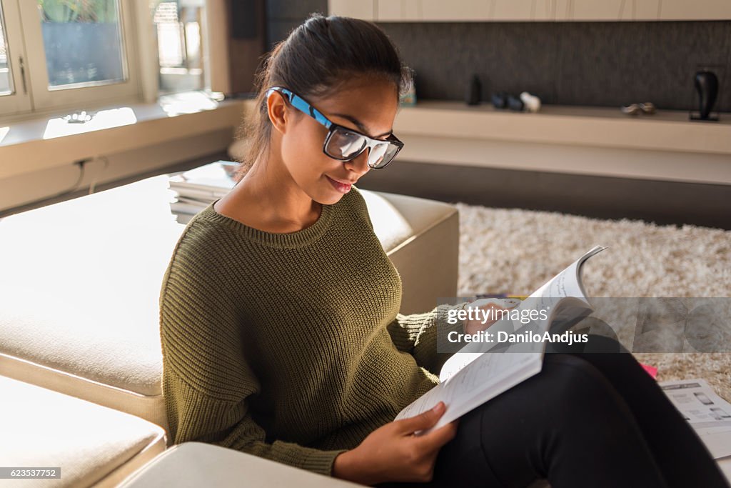 Young woman reading a book at home