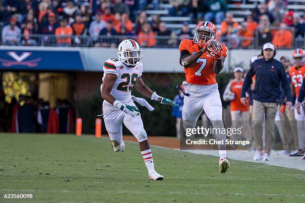 Doni Dowling of the Virginia Cavaliers pulls in a pass over Corn Elder of the Miami Hurricanes during a game at Scott Stadium on November 12, 2016 in...