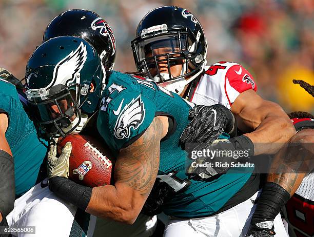 Ryan Mathews of the Philadelphia Eagles runs for a first down and is tackled by Vic Beasley Jr. #44 and Courtney Upshaw of the Atlanta Falcons in the...