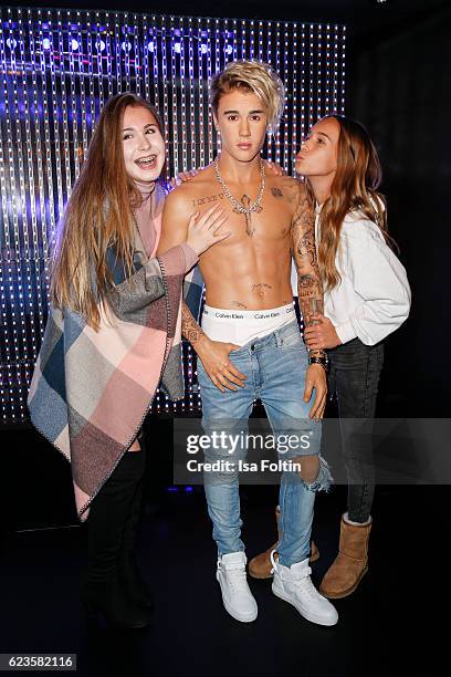 Youtuber Kassii and youtuber Nona pose with the Justin Bieber wax figure during the unveiling of the Justin Bieber wax figure at Madame Tussauds on...