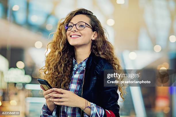 junges schönes mädchen ist in der mall einkaufen. - phone charging stock-fotos und bilder