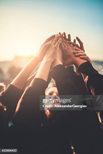 group of teenagers volunteer with raised hands to the sky - city friends sun bildbanksfoton och bilder
