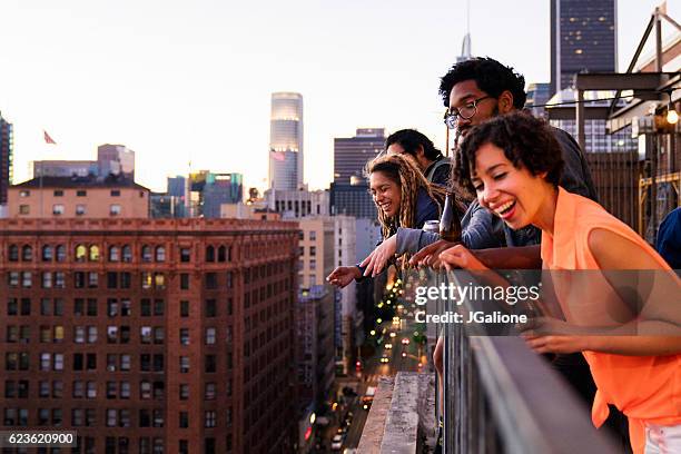 group of friends hanging out together - rooftop friends stock pictures, royalty-free photos & images