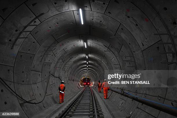 Construction workers work on a section of train track inside a Crossrail tunnel, beneath Stepney in east London on November 16, 2016. The Crossrail...